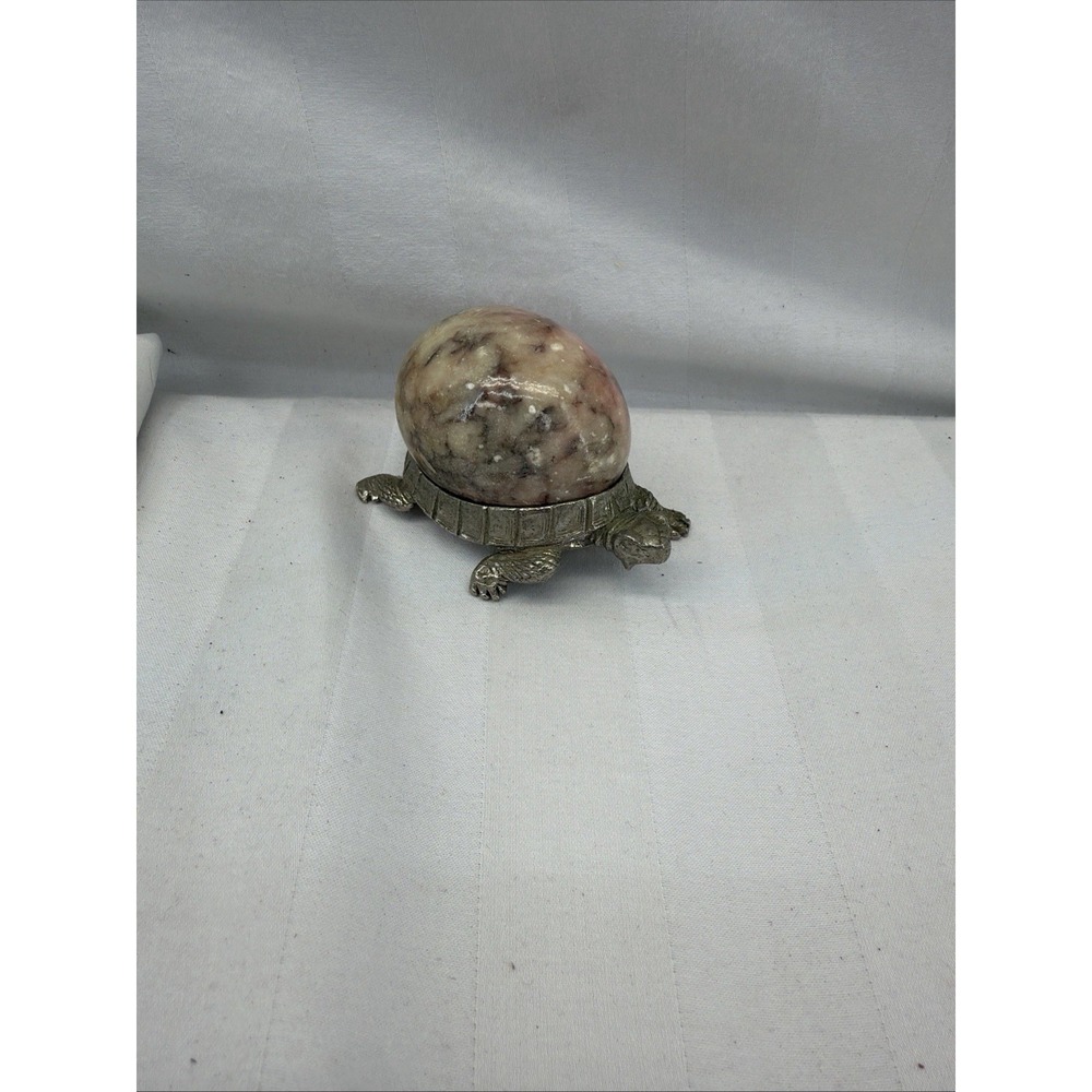 vintage figurine of a natural stone egg resting on a cast metal turtle stand